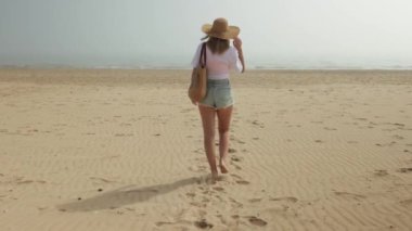 Kız sabah kumsalda yürüyor..