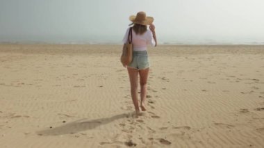 Kız sabah kumsalda yürüyor..