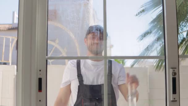 Młody Człowiek Myjący Okna Szklanym Oknem Sprzątający Dom — Wideo stockowe
