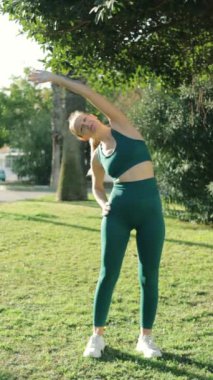 Park 'ta yoga yapan genç bir kadın.