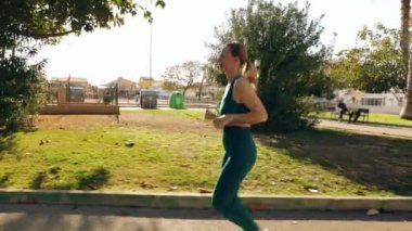 Güzel kız şehir parkında jimnastik yapıyor..