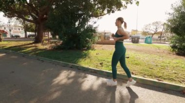 Parkta egzersiz yapan genç bir kadın.