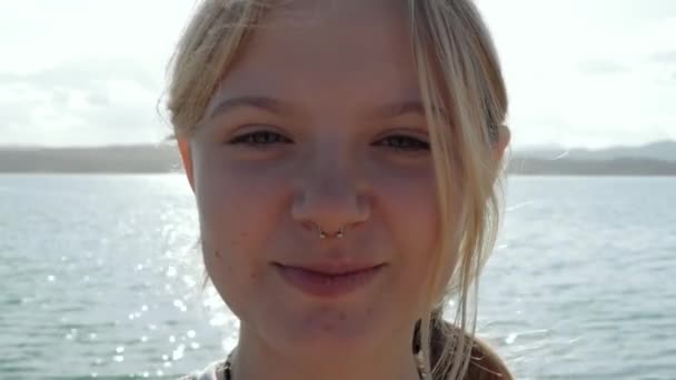 年轻美丽的女孩在大海的背景下在户外咀嚼口香糖 优质Fullhd影片 — 图库视频影像