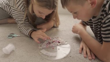 Kız renkli kalemleri plastik bir torbadan topluyor.