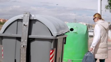 Dışarıdaki çöpleri çöp kutusuna atan kadın..