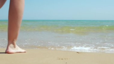 Kumsalda yürüyen bir kadın