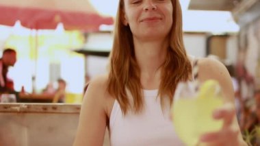 Kafede bir bardak meyve suyu içen genç bir kadının portresi