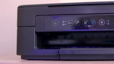Lazer yazıcı çok renkli ışığın altında masanın üzerinde duruyor. Yüksek kalite 4k görüntü