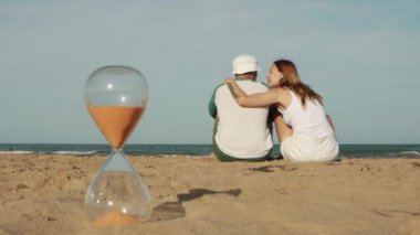 Kumsalda bir şişe suyu olan çift.