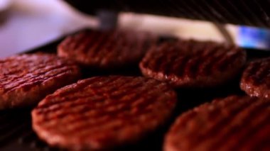 Hamburger ızgarası. Hamburger hazır, spatulası olan şef de burgeri ızgaradan çıkardı. Et suyu ve yağın geri kalanı ızgarada kalacak. Yüksek kaliteli FullHD görüntüler