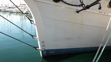 İskelede su üstünde yüzen, dalgalarda sallanan, yan manzaralı eski bir teknenin pruvası. Yaklaş. Pürüzsüz yüzey göleti etrafındaki dünyayı ayna gibi yansıtır. Yüksek kalite 4k görüntü