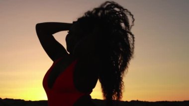 Gün batımında güzel bir kadının silueti.