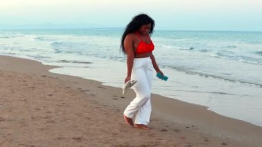 Deniz kıyısı üzerinde yürüyen kadın