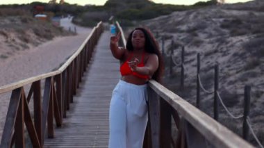 Kumsalda kırmızı elbiseli güzel bir kadın.