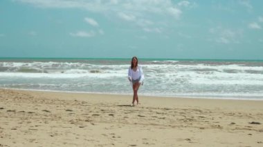 Deniz kıyısındaki genç bir kadın. Yazın kumsalda güzel bir kadın.