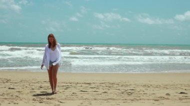 Kumsalda yürüyen genç mutlu kadın