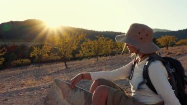 Sırt çantalı bir kadın yürüyüşçü bir dağ manzarasında oturuyor. yüksek kaliteli fotoğraf