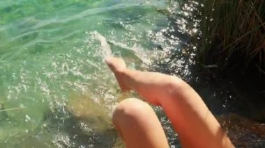Sahilde kadın ayakları ve bacakları, su sıçrıyor