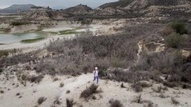 Uçurumda yürüyen ve güzel manzaranın tadını çıkaran bir kadın yürüyüşçü.