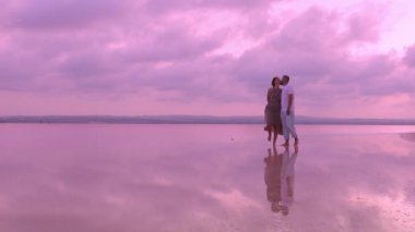 Kumsalda duran bir çiftin silueti.