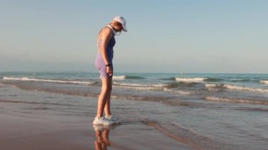 Kumsalda yürüyen güzel kadın