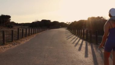 Gün batımında tarlada koşan kadın.