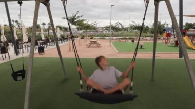 Çocuk parkında egzersiz yapan genç bir adam..