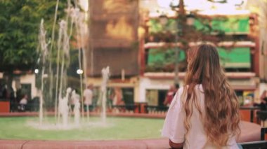 Sokakta oturan genç kadın.