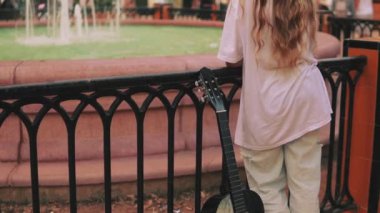 Şehir parkında yürüyen uzun saçlı güzel bir genç kadın..