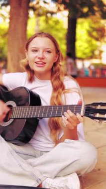Akustik gitarı olan bir kız.