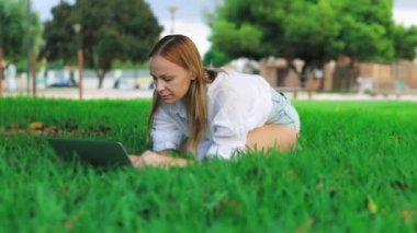 Parkta dizüstü bilgisayarı olan kadın.