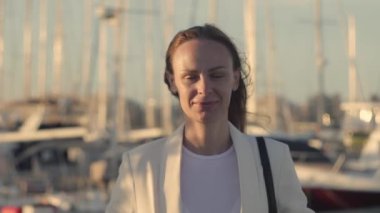 Genç bir kadın yat kulübünde duruyor..