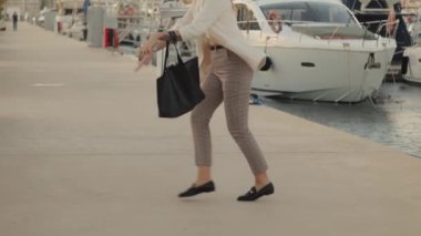 Teknelerle marinada yürüyen güzel bir kadın.