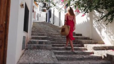 Rhodes şehrinin dar sokaklarında yürüyen bir kız.