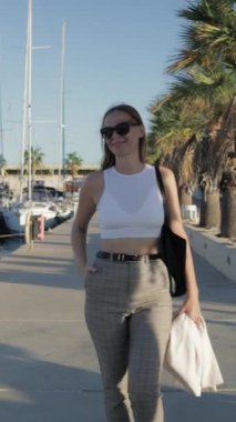 Genç güzel bir kadın sahilde poz veriyor.