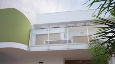 Balkonu ve balkonu olan modern bir binanın ön cephesi.