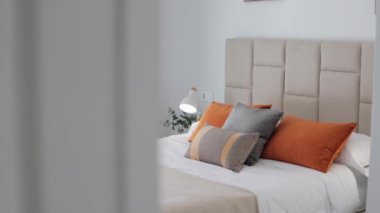 Modern yatak odasının içinde yastıklar ve lambalar var.