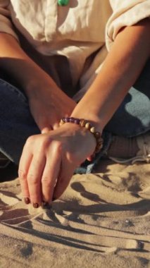 Kadın eli bilezik ve bilezik ile kumsalda