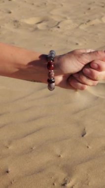 Kızıl kumla el ele tutuşan kadın.