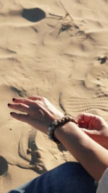 Kumda kum tutan bir el.