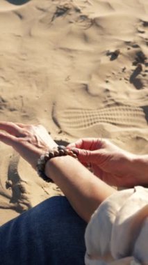 Kumsalda yüzüğü olan bir kadın.