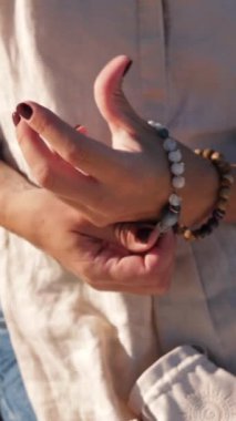 Beyaz bir bilezik ile bir kadının ellerine yakın çekim..