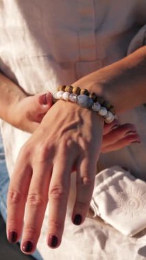 Beyaz gömlekli ve siyah mücevherli kadın ellerini kapat.