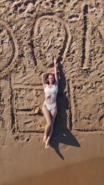 Plajda sörf tahtası olan kadın..