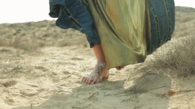 Sahilde elbise giymiş genç bir kadın.