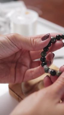 Masada boncukları olan bir kadının ellerini kapat.