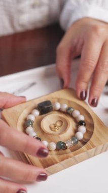 Kadın elleri tahta bir kutuda mücevher yapıyor.