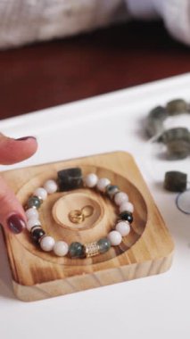 Kadının elleri, elinde bileziğiyle tahta bir kutu tutarken yakın çekimde.