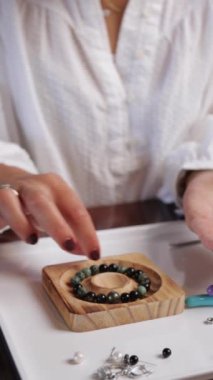 Boncuklardan el yapımı mücevherler yapan bir kadın. El yapımı mücevherler.