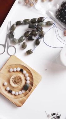 Bir mücevher, siyah boncuklu bir kolye ve beyaz boncuklu bir fotoğraf.